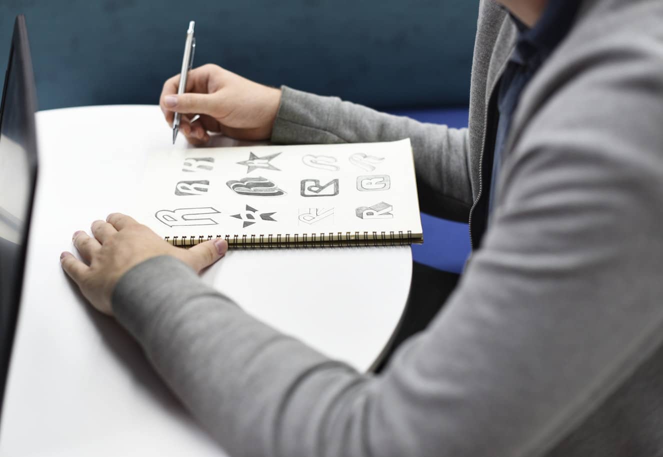 A woman sketching on a brand identity