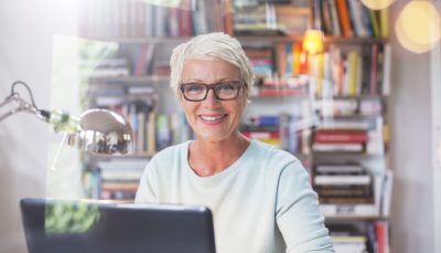 Businesswoman smiling at computer in home office